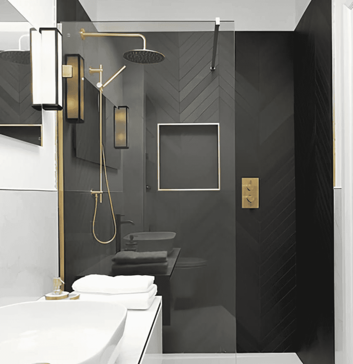 Bathroom with a charcoal herringbone tiled shower and brass fixtures